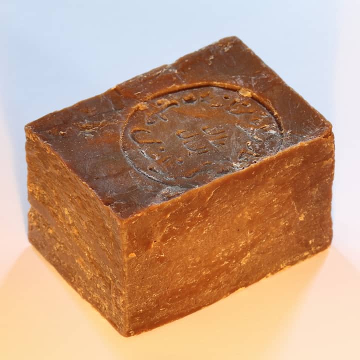 Phone photo of an Aleppo soap bar on a table in warm light